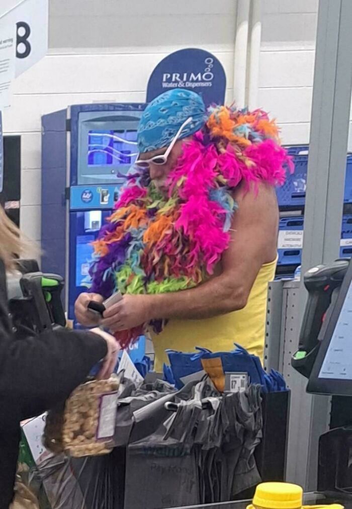 Man at Walmart checkout wearing colorful feather boa