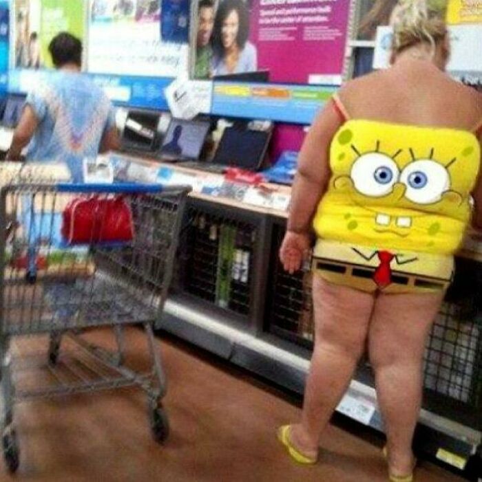 Person wearing SpongeBob SquarePants outfit shopping inside Walmart electronics section