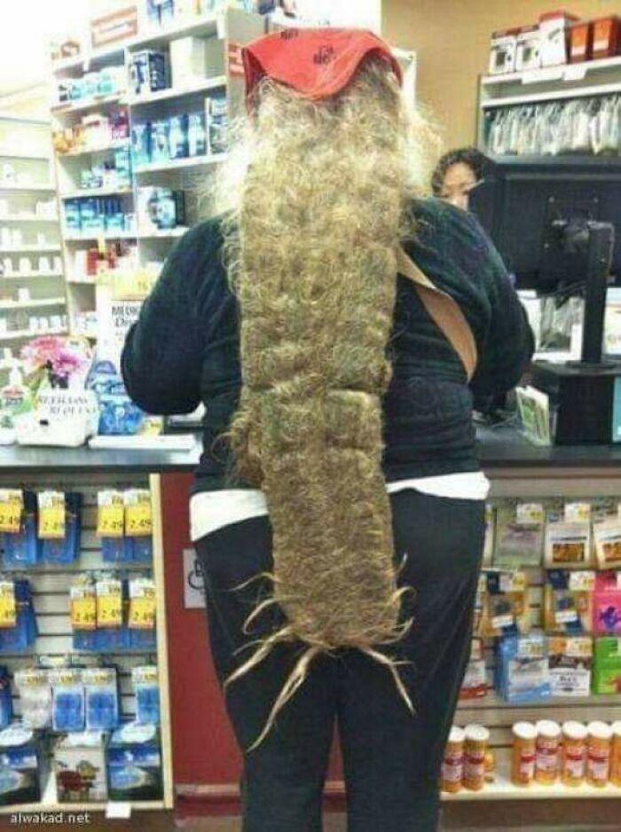 Person with extremely long curly hair in Walmart pharmacy area