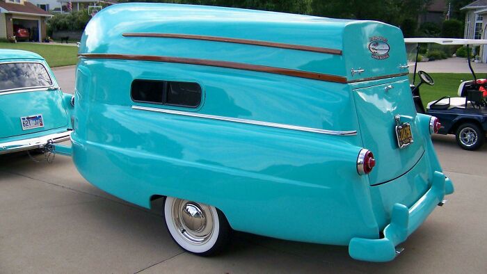 Rare historical photo of a vintage turquoise caravan trailer attached to a classic car