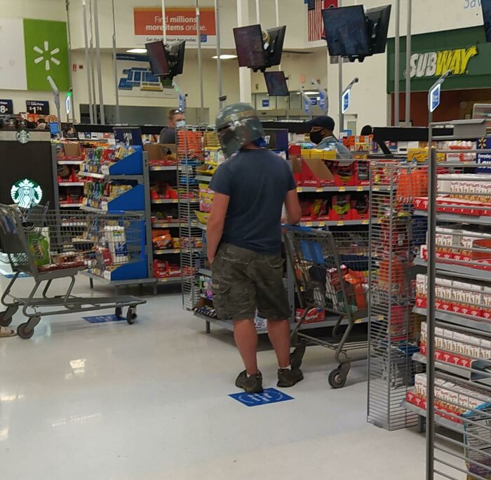 Walmart customer wearing helmet standing in checkout line