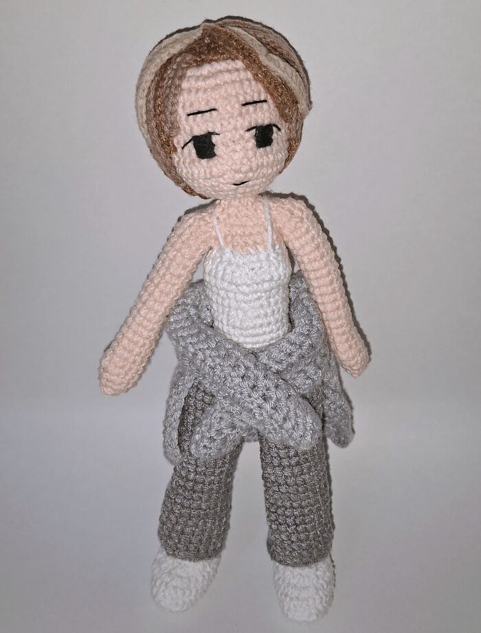 Crochet doll with brown hair and gray pants handmade with yarn