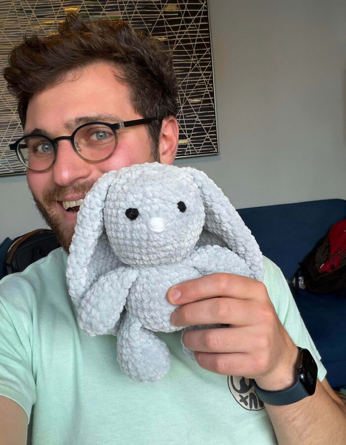 Man holding crochet stuffed animal bunny with yarn texture