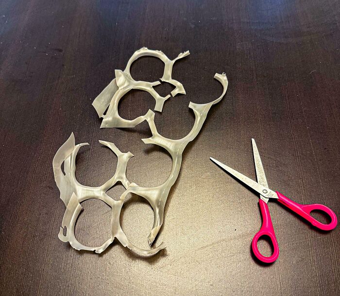 Cut plastic six-pack rings with scissors on table nostalgic 90s memes