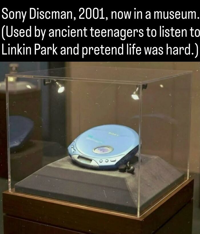 A retro Sony Discman inside a display case showcasing history photos and facts