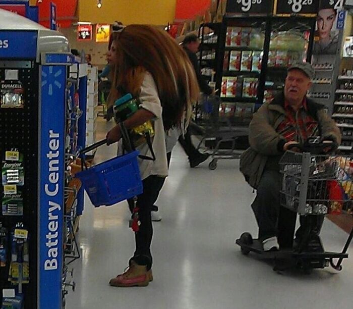 Woman shopping at Walmart Battery Center with man on mobility scooter