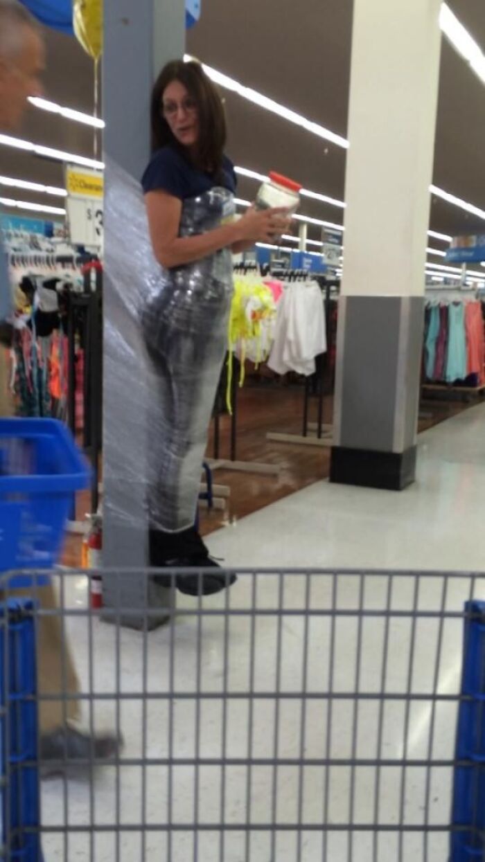 Woman wrapped in plastic film stuck to store pole inside Walmart