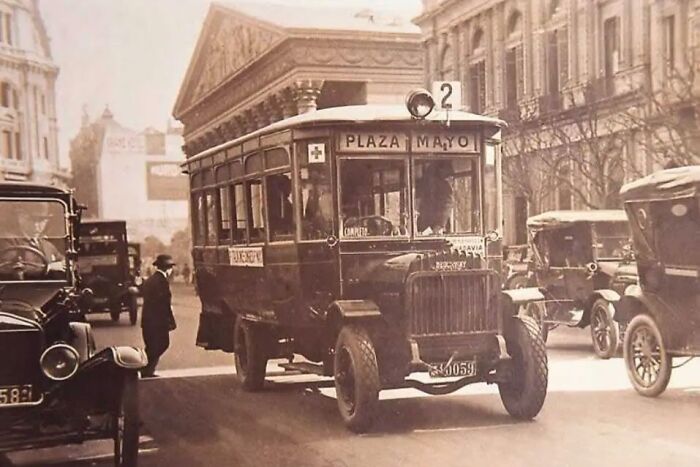 Rare historical photo of vintage bus in old city street traffic