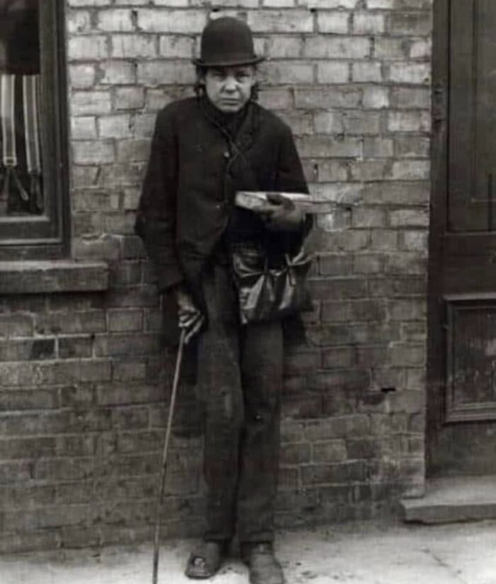 Black and white rare historical photo of man in bowler hat holding cane and box