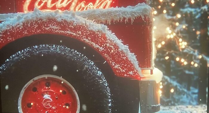 Snow-covered red Coca-Cola truck tire in winter scene