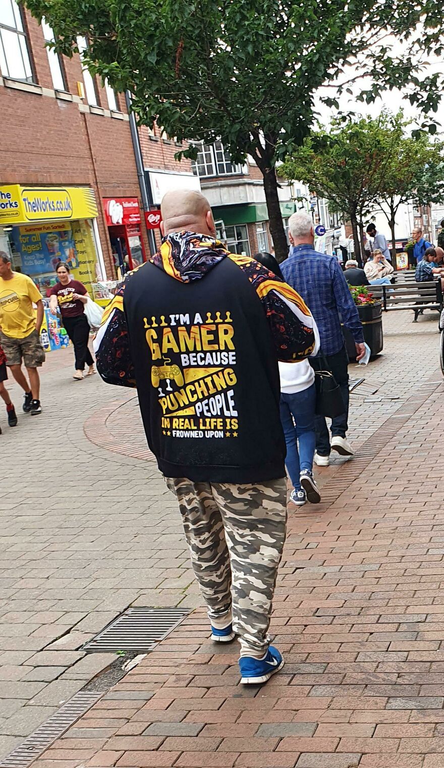 Man wearing hoodie saying I'm a gamer because punching people in real life is frowned upon walking in town