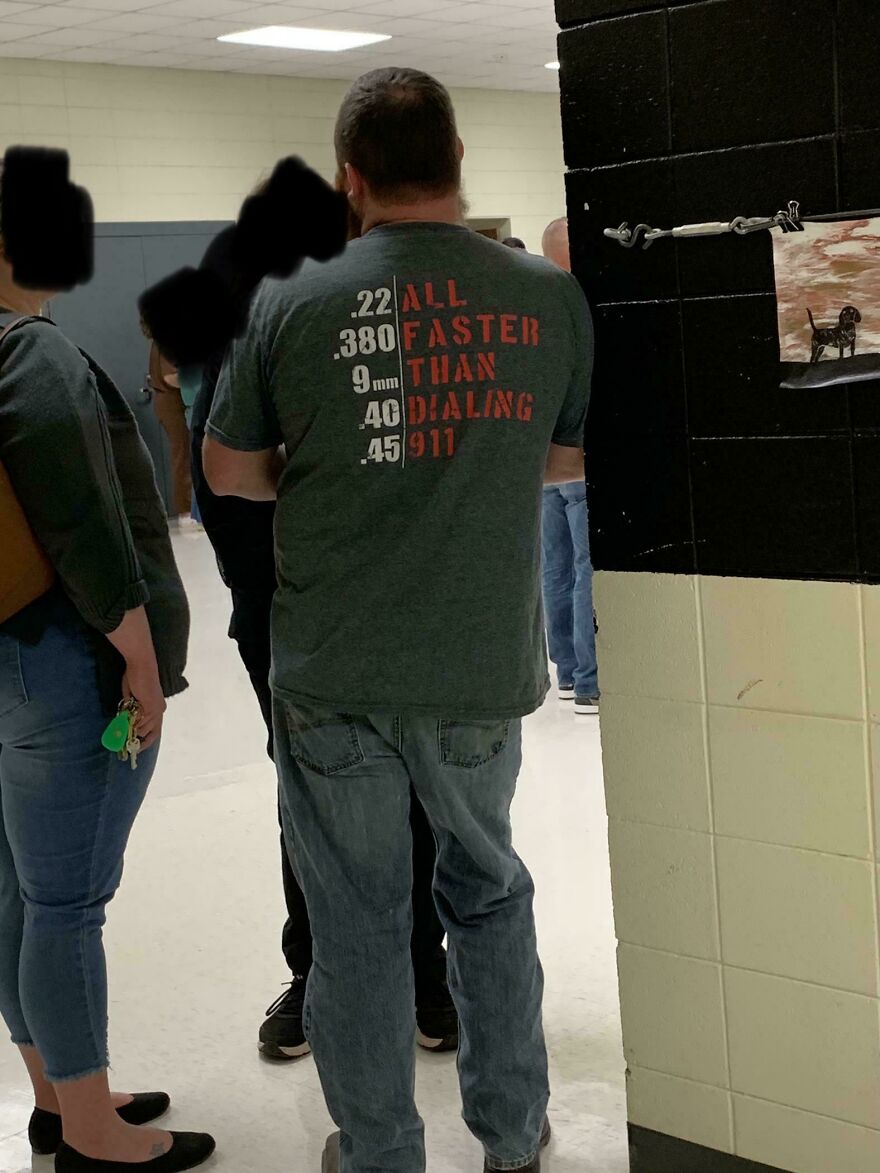 Man wearing shirt with text about guns faster than dialing 911