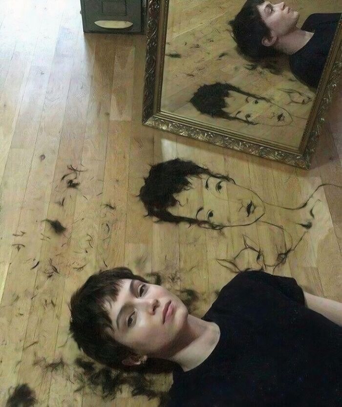 Creative artwork on a wooden floor using hair clippings, featured in amusing posts.