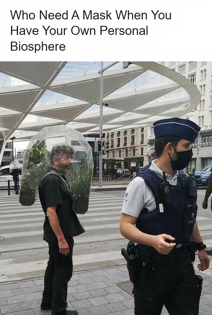 Funny pics of a man wearing a wearable plant biosphere bubble on a city street.