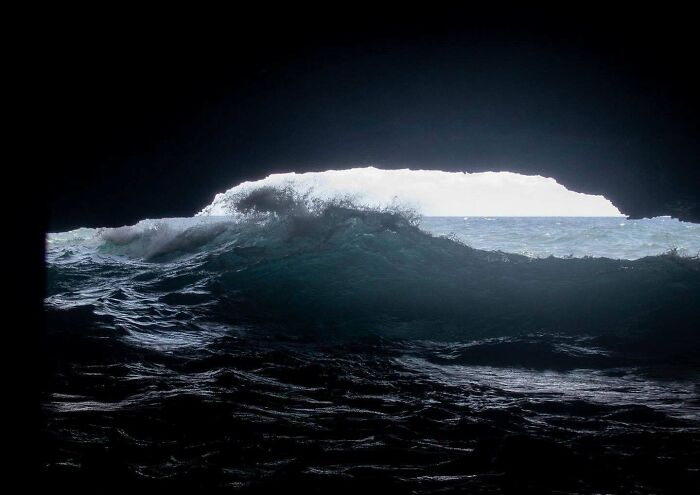 View of dark ocean waves from inside deep-water cave