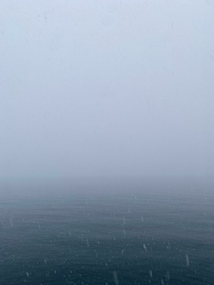 Foggy deep-water sea with low visibility and falling rain