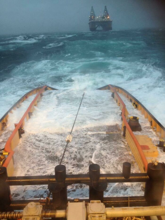 Rough sea waves near an offshore platform seen from a boat deck in deep water