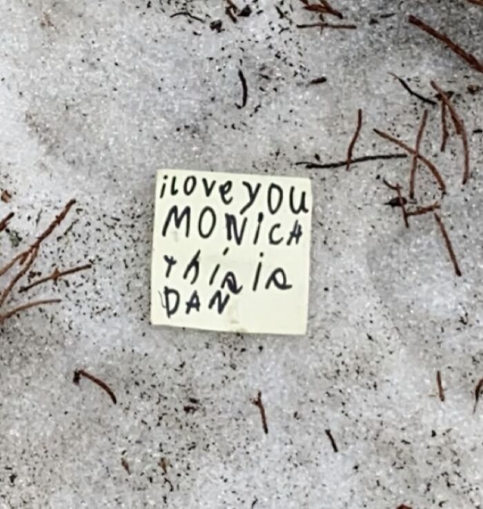 A small note in the snow reading I love you Monica this is Dan, showcasing lost and forgotten messages.