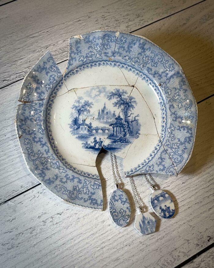 Broken blue and white ceramic plate repurposed into decorative pendants, proving creativity can save money.