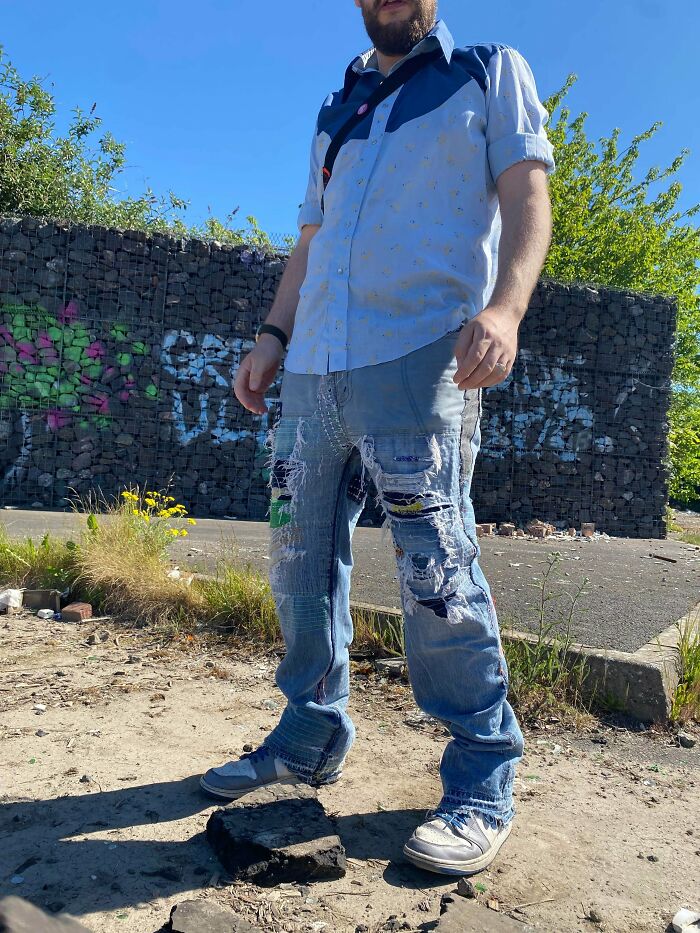 A person wearing custom mended denim jeans, proving creativity can save money through visible repair art.