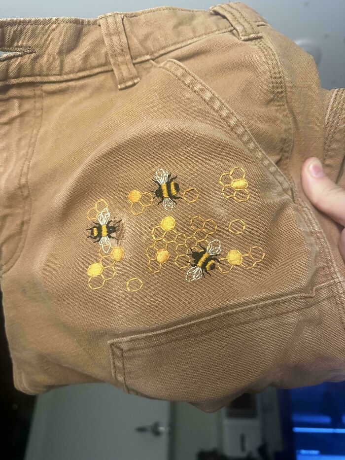 Brown pants with embroidered bees and honeycomb, demonstrating creativity to save money on clothes.