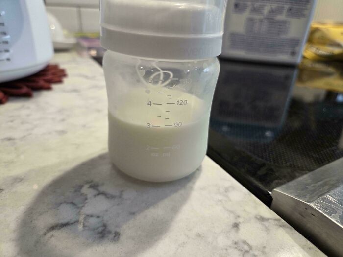 A baby bottle filled with milk sitting on a counter, showing a dad prepared for daily parenting duties.