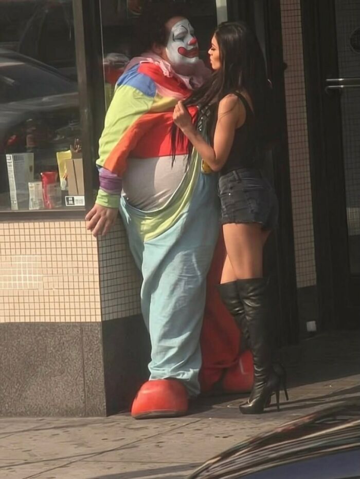 Weird and funny photos of a woman talking closely with someone in a clown costume.