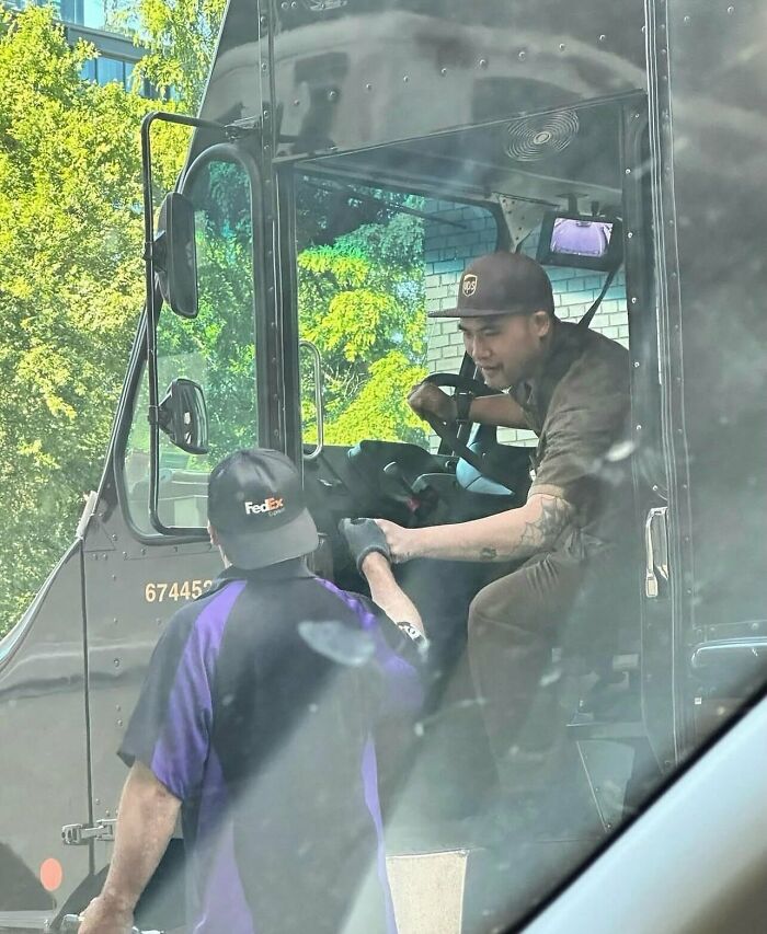 UPS and FedEx drivers interacting from their delivery trucks in one of many funny random photos.