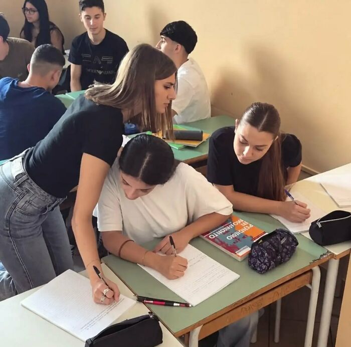 A optical illusion picture of a student writing with three hands, representing weird photos that need a second look