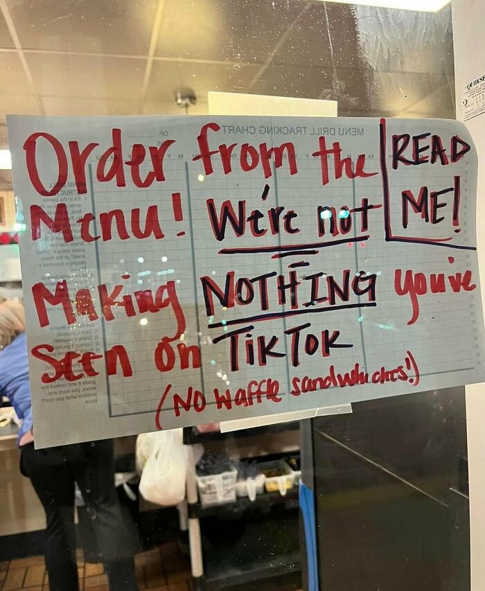 Handwritten sign on a window instructing customers to order from the menu in weird and funny photos.