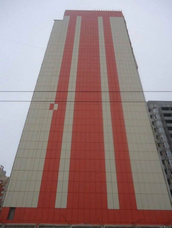 A tall building with a single misplaced tile featured among weird and funny photos.