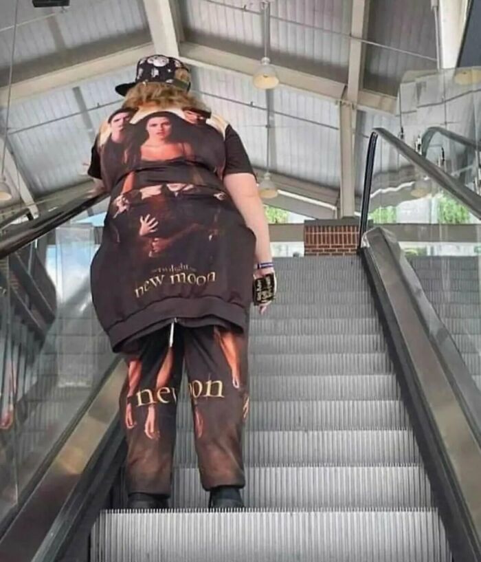 A person riding an escalator wearing full Twilight merchandise from a list of weird and funny photos.