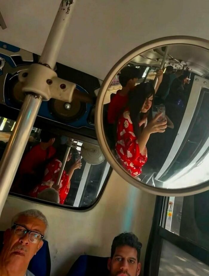 Passengers on a public bus captured in a mirror reflection, showcasing random funny moments.