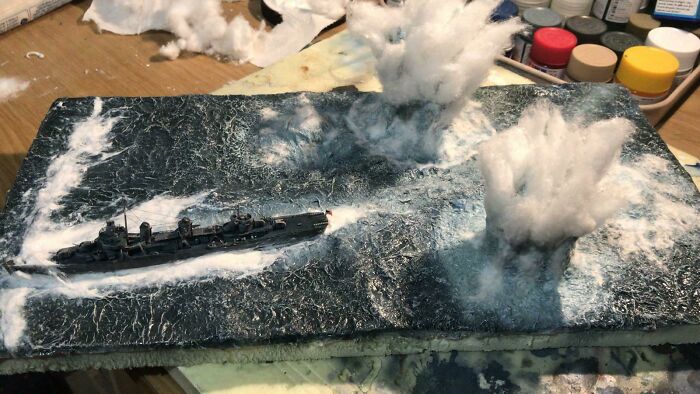 Miniature models showing naval battle with ship and water explosions scene
