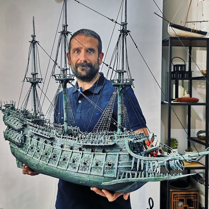 Handcrafted detailed miniature ship model held by a man showcasing craftsmanship