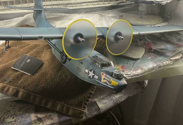 Close-up of a detailed miniature World War II aircraft model with propellers