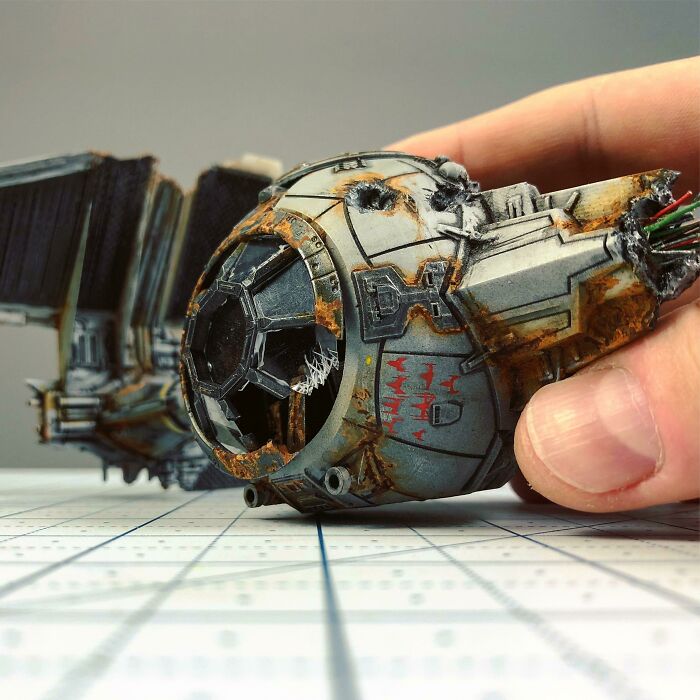 Rusty detailed miniature model of a spacecraft held by hand showcasing craftsmanship