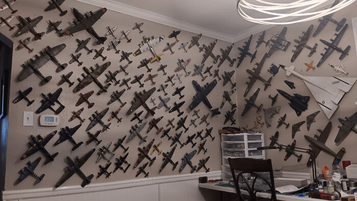 Collection of miniature airplane models displayed on walls with detailed craftsmanship