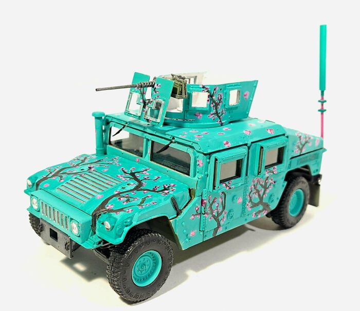 Turquoise military vehicle miniature with artistic cherry blossom painting