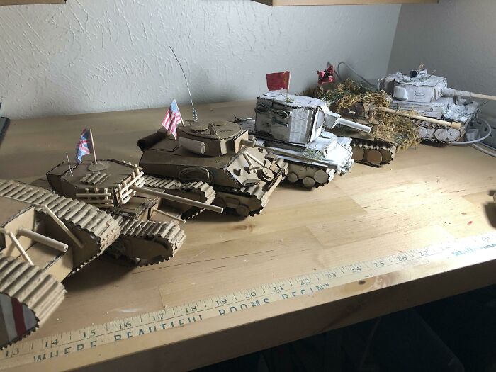 Handmade miniature tank models displayed on a wooden table