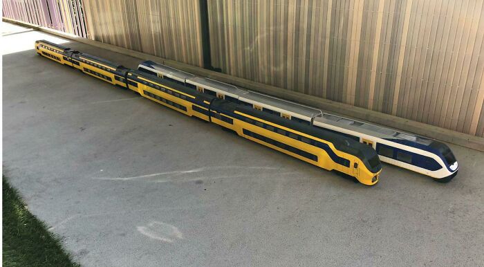 Detailed miniature models of yellow and white trains on a platform