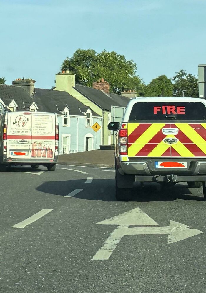 Fire service vehicle and antifire van near houses on a curved road