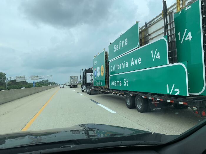 Highway truck carrying oversized road signs showing a glitch in the matrix