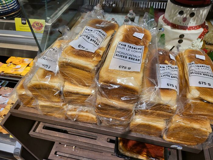 Loaves of horizontally sliced bread stacked in plastic packaging glitch
