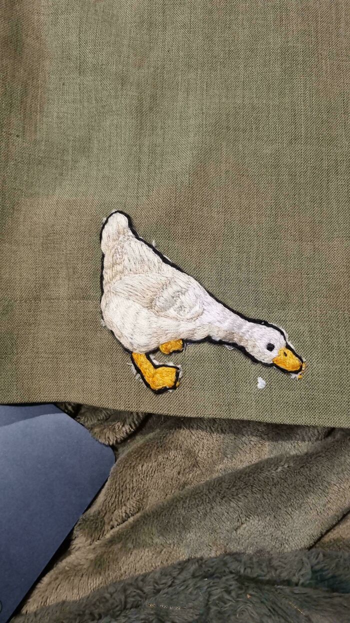 Embroidered white duck patch on olive fabric, illustrating how a little creativity saves money.
