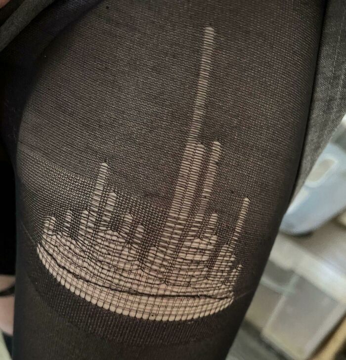 Sheer black stockings torn in a glitch pattern resembling middle finger shape