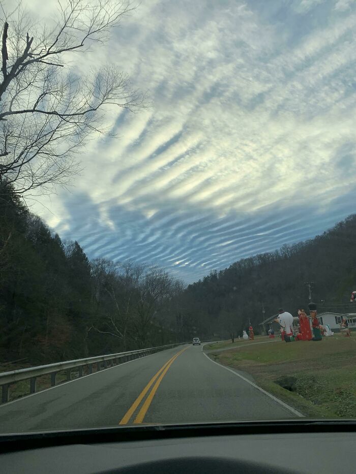 Road under sky with unusual ripple clouds glitch in the matrix