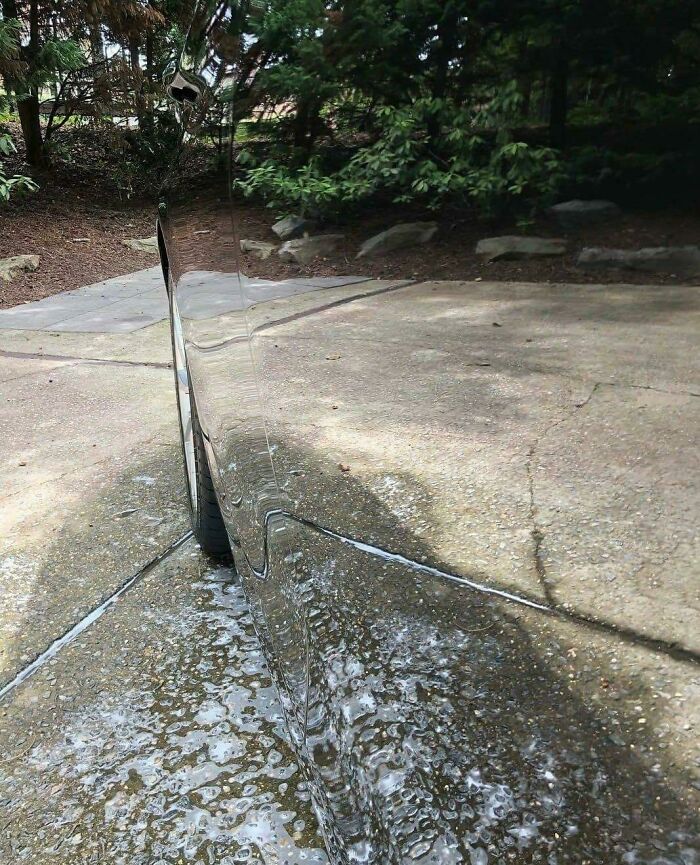Reflective car surface showing distorted driveway glitch effect