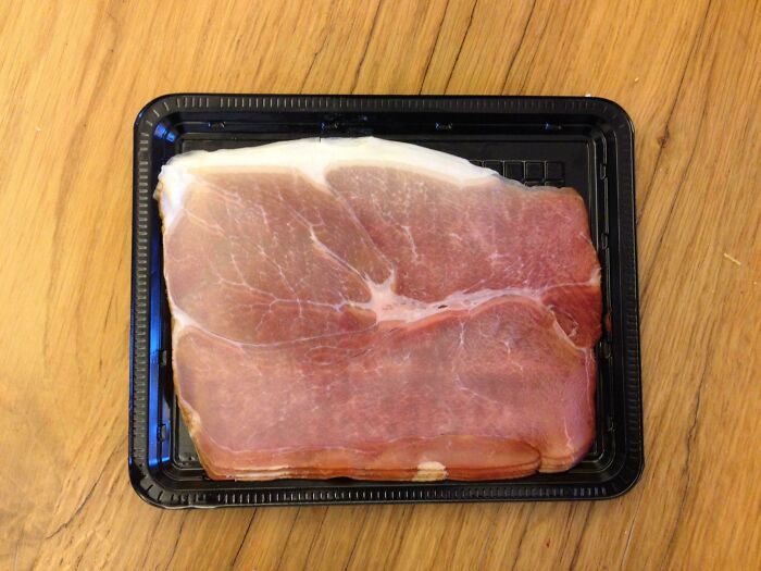 Slice of ham in a plastic tray resembling a glitch pattern