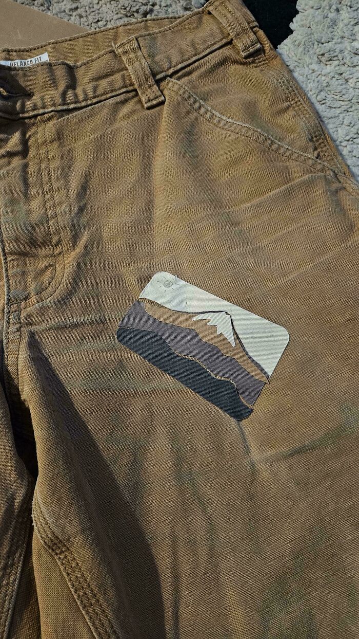 Brown pants patched with a custom mountain design using creativity to save money